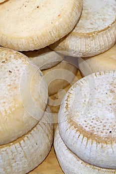 Forms with freshly made cheese on wooden table