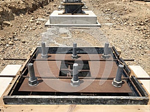 Formwork and reinforcement of concrete foundation with metal anchor bolts designed for the installation of metal columns