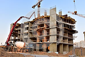 Formworks and pouring concrete through a Ñoncrete pump truck connected to a ready-mixed truck. Concrete line and boom pumping at