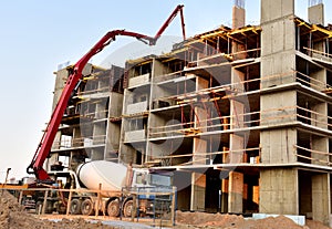 Formworks and pouring concrete through a Ñoncrete pump truck connected to a ready-mixed truck. Concrete line and boom pumping at