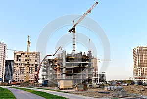 Formworks and pouring concrete through a Ñoncrete pump truck connected to a ready-mixed truck. Tower cranes in action at