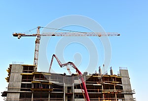 Formworks and pouring concrete through a Ñoncrete pump truck connected to a ready-mixed truck. Tower cranes in action at