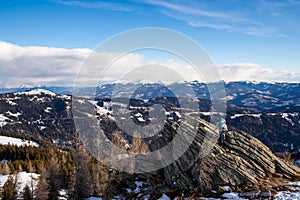 Forstalpe - Woman with backpack standing on massive rock formation at Steinerne Hochzeit, Saualpe, Lavanttal Alps, Austria