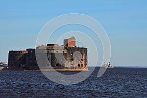Fort Alexander I in the Gulf of Finland and a cargo ship in Kronstadt, St. Petersburg, Russia