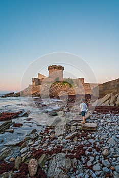 Fort de Socoa with a man standing on the unique flysch landform beach at sunset in Ciboure and Saint-Jean-de-Luz