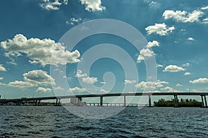 Fort Myers Landscape and Cityscape with Water and Cloudy Blue Sky. Caloosahatchee river and Bridges.