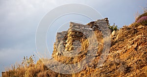 Fort ruins at Tzia, Kea island, Greece. Under view of red stonewall of ancient castle background