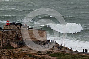 Fort of Sao Miguel Arcanjo Lighthouse in Nazare, Portugal. Big Waves on Cloudy Day photo