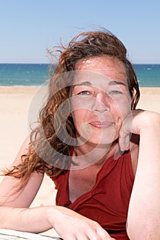 Forties smiling woman at the beach