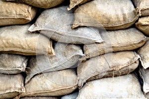 Fortification army building of sandbags. Texture of stuffed burlap retro bags. Background of dusty sackcloth