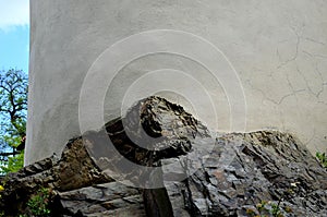 Fortification wall on a rocky cliff top. round building with white old plaster. naval lighthouse. the rock penetrates inside the w