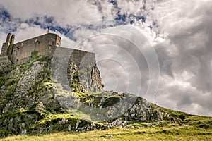 A fortress on a cliff with clouds