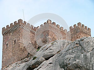 A fortress in the Romanesque style of the time of the knights, which stands on the edge of a stone cliff.