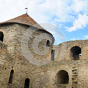 Fortress tower with tiled roof on blue sky background. Location