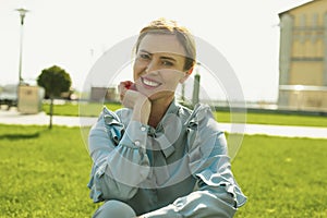 Fortunate lovely woman sitting on green grass