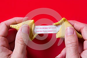 Fortune cookie with message on paper on red background