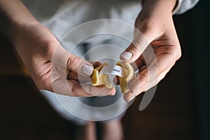 Fortune cookie message in woman`s hands