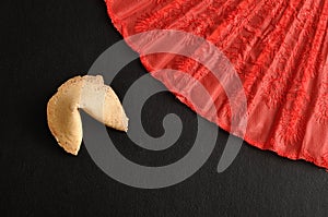 Fortune cookie and a red hand fan