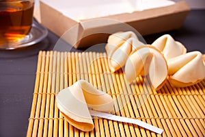Fortune cookies and cup of tea on the wooden table