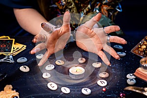A fortune teller conjures a candle surrounded by runes and the magic aura. The concept of divination, astrology and predicting the photo