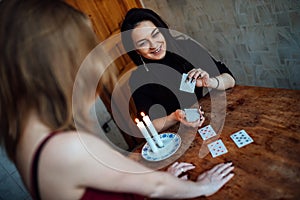 A fortune teller predicts the fate and future of a girl on tarot cards photo