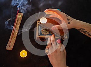 Fortune teller using tarot cards on black background