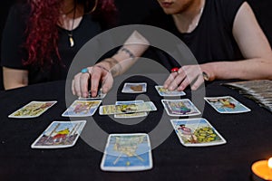 Fortune teller using tarot cards on black background