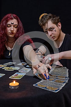 Fortune teller using tarot cards on black background