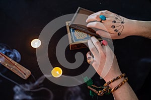 Fortune teller using tarot cards on black background