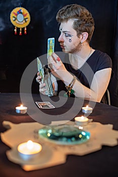 Fortune teller using tarot cards on black background