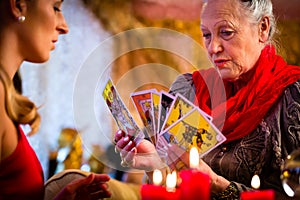 Fortuneteller laying Tarot cards with client