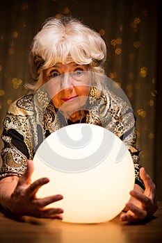 Fortuneteller looking into crystal ball photo