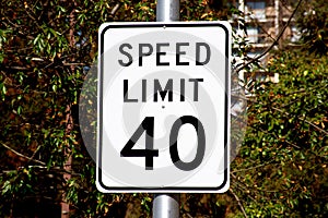 Forty mph speed limit sign on urban road. Speed zone traffic sign against tree landscape