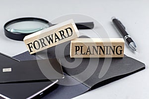 FORWARD PLANNING text on wooden block on black notebook , business concept