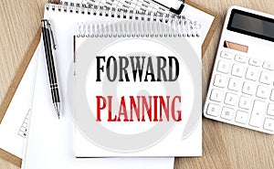 FORWARD PLANNING is written in white notepad near a calculator, clipboard and pen. Business concept