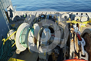 Forward port side mooring winch and anchor windlass with chain and heaved up green manila rope.