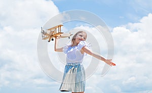 Forward to adventure. teen girl play with wooden plane. kid fashion style. concept of traveling. happy childhood. cute