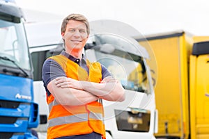 Forwarder or driver in front of trucks in depot