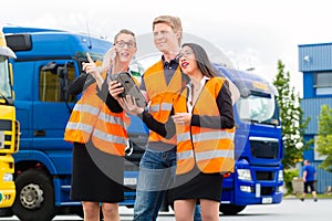 Forwarder in front of trucks on a depot