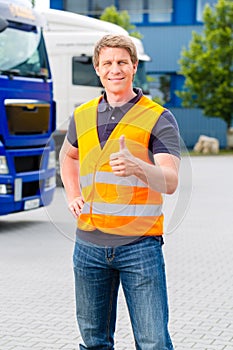 Forwarder in front of trucks on a depot