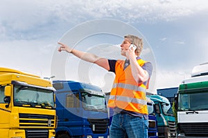 Forwarder in front of trucks on a depot