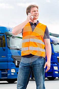 Forwarder in front of trucks on a depot