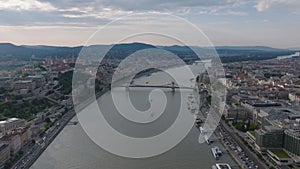 Forwards fly above Danube river in city. Historic buildings and tourist sights on waterfronts. Budapest, Hungary