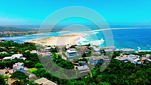 Forwards fly above luxury residencies above sea coast. Aerial view of coastal town. Plettenberg Bay, South Africa