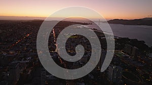 Forwards fly above metropolis at sunset. Urban borough, water in San Francisco Bay, Golden Gate Bridge and colour