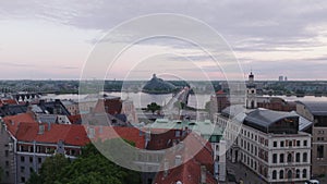 Forwards fly above old buildings in historic city centre near wide river on cloudy day. House of the Blackheads with