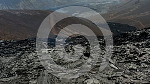 Forwards fly above rugged surface of new lava field. Cooling and hardening layer of erupted magmatic material