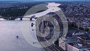 Forwards fly above wide river Danube in city. Beautiful popular building of Hungarian Parliament. Orszaghaz on