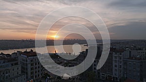 Forwards fly over apartment buildings. Revealing panoramic view of city and water surface against color sunset sky