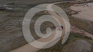 Forwards tracking of offroad car on dirt track in wasteland. High angle view of moving vehicle. Iceland